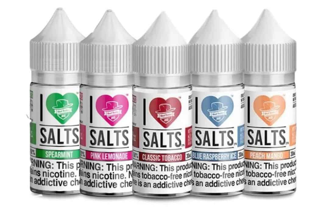 Assorted vape salt bottles featuring flavors like spearmint, pink lemonade, classic tobacco, blue raspberry, and peach mango for e-cigarette users.
