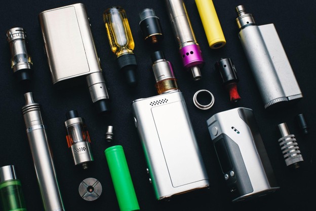 Collection of vape devices, e-cigarettes, and accessories including batteries, tanks, and mods for vaping enthusiasts.